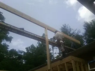 Carpenter setting a ridge beam over a new addition frame — Ice Dam Removal by Roofing Brothers in Silvis