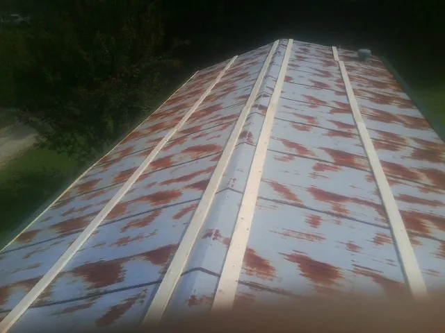 Rusted metal roof panels with new wood purlins before replacement — Storm Damage Roof Repair in Silvis by Roofing Brothers