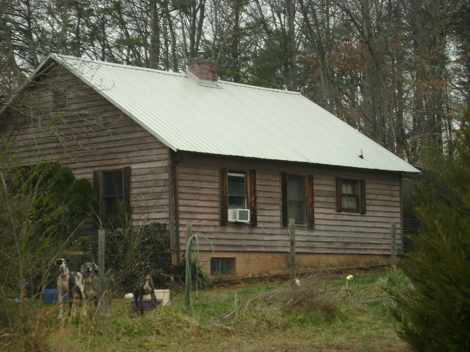 White metal roof on an old wood sided farmhouse, from a Metal Roof Installation job in Silvis